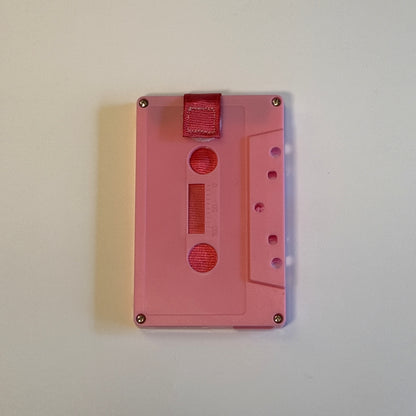 Solid pink cassette wallet with a deep pink pull strap