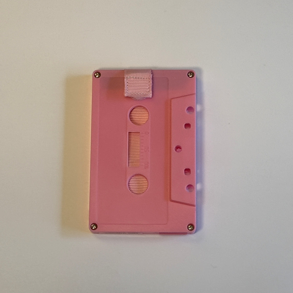 Solid pink cassette wallet with a light pink pull strap
