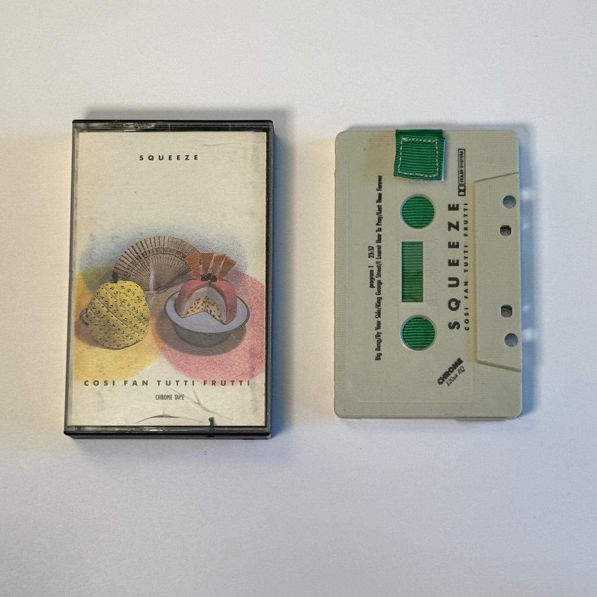 Squeeze Cosi Fan Tutti Frutti white cassette wallet with a green pull tab beside the original case