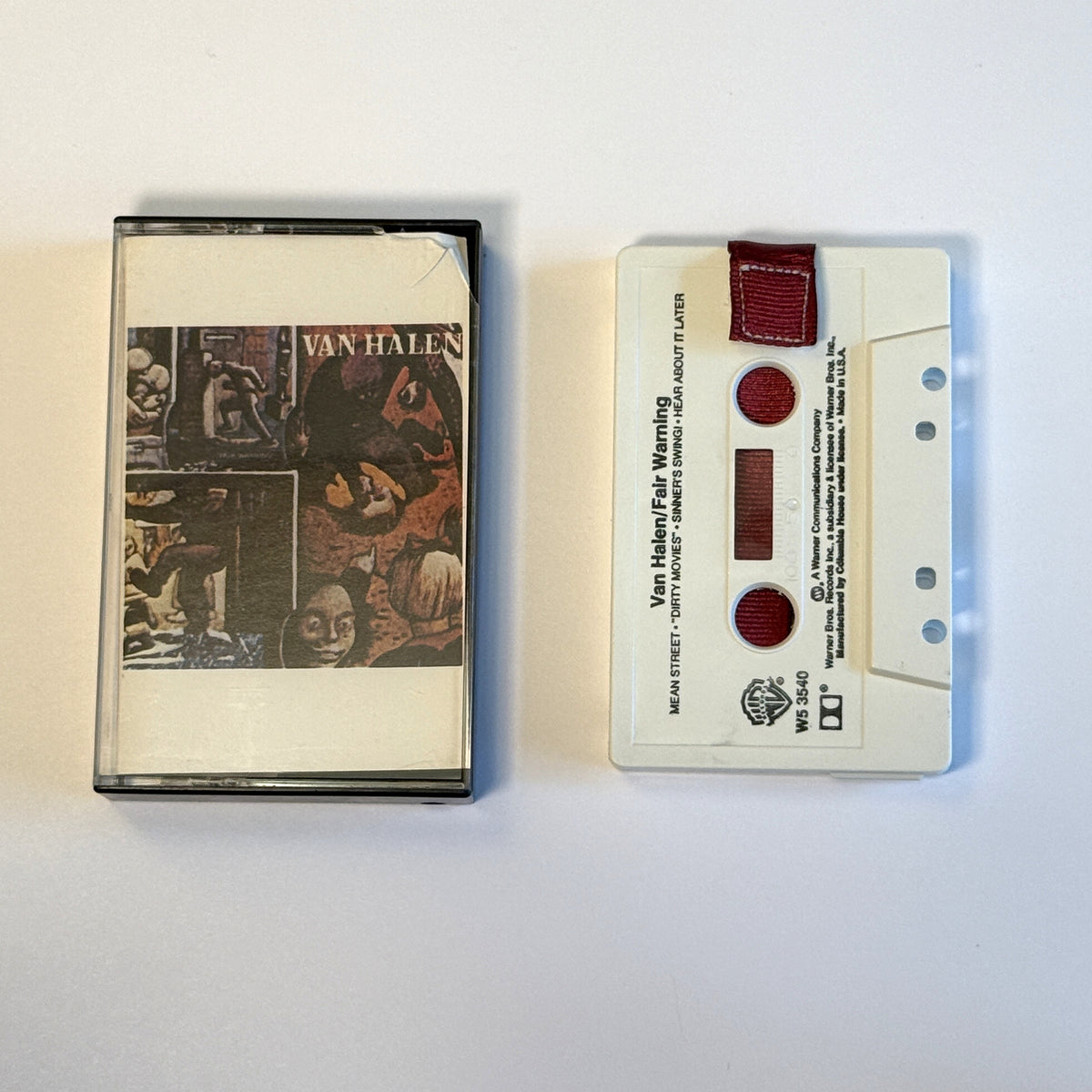 Van Halen Fair Warning gray cassette wallet with a burgundy pull tab beside the original case